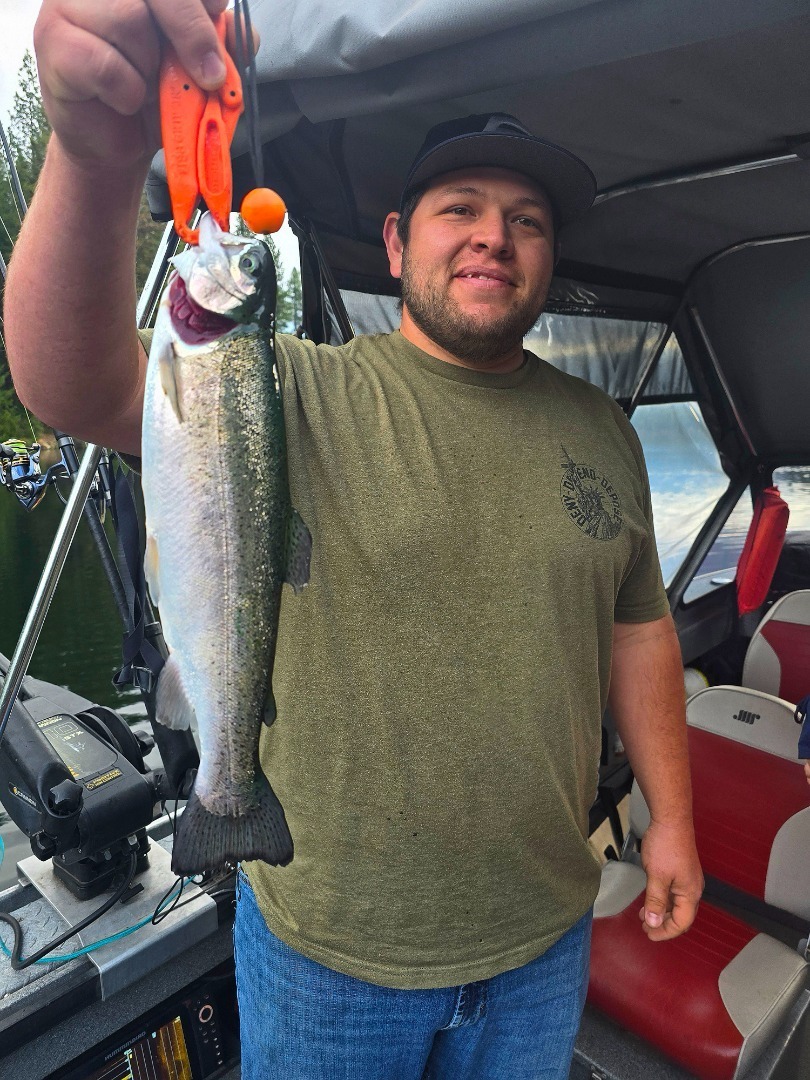 Angler holding a Shasta Lake rainbow trout caught aboard Scott Caldwell's guide boat