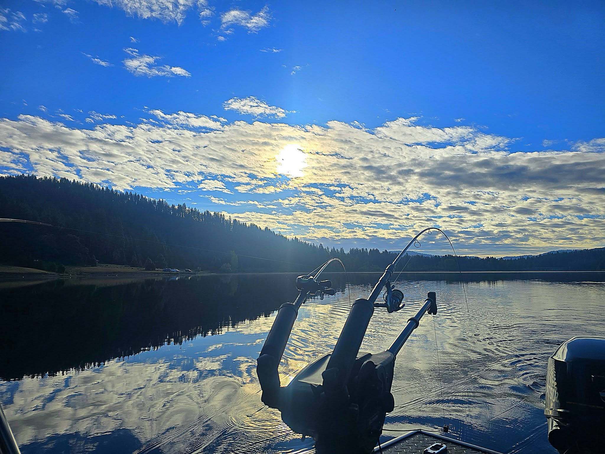 Trolling rods set in their holders at first light on a glassy Shasta Lake